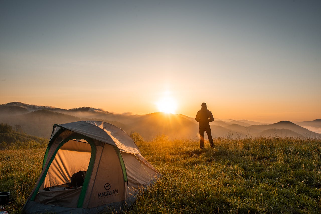 Silhouette of Person Standing Near Camping Tent